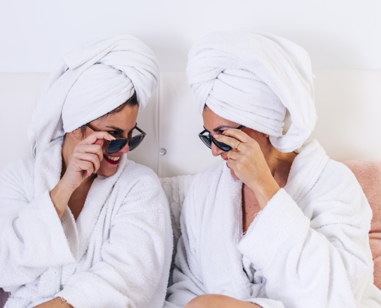 two ladies wearing shades and white robe in spa