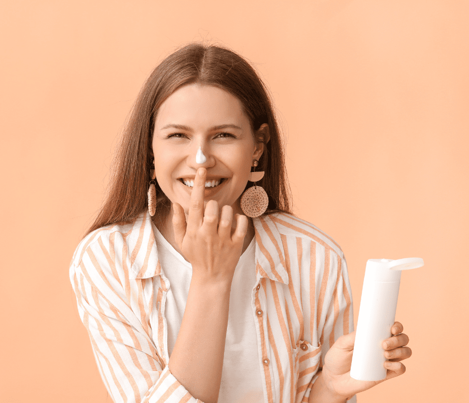 woman applying sunscreen to her nose while holding the item