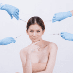 a woman and four gloved hands holding a syringe