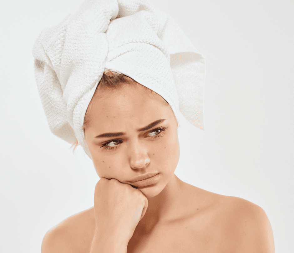 a woman with acne and a towel wrapped around her head