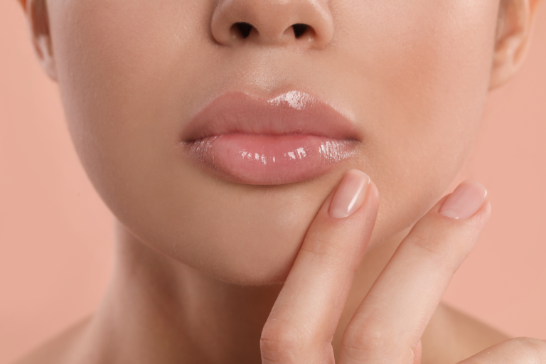 young woman with beautiful full lips on peach background