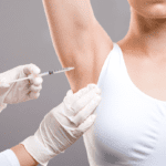 a doctor injecting a patient in the armpit