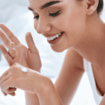 beautiful woman putting lotion on hands