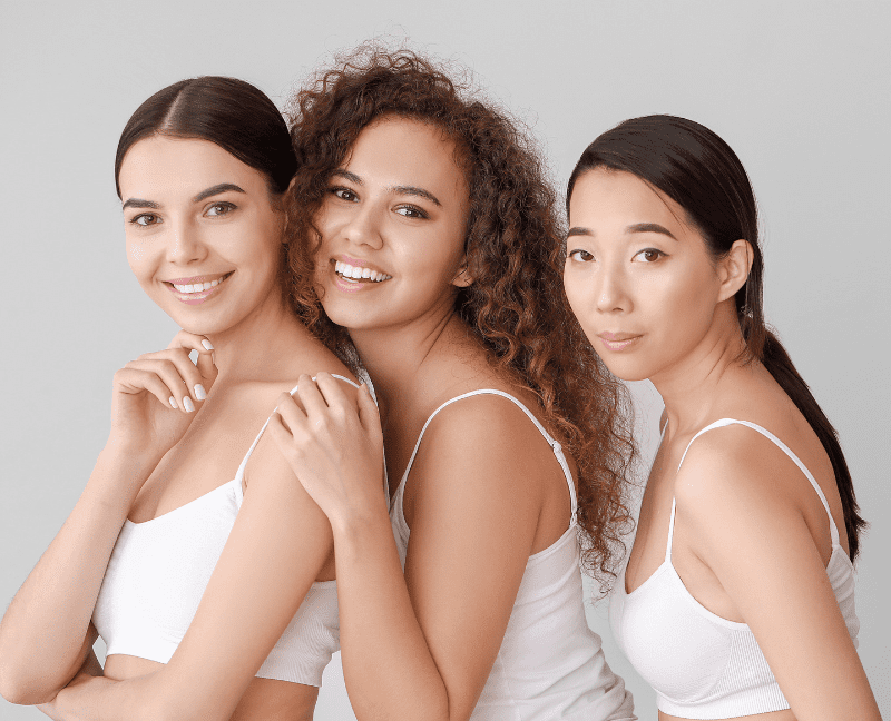 three multicultural women posing and smiling after iv therapy