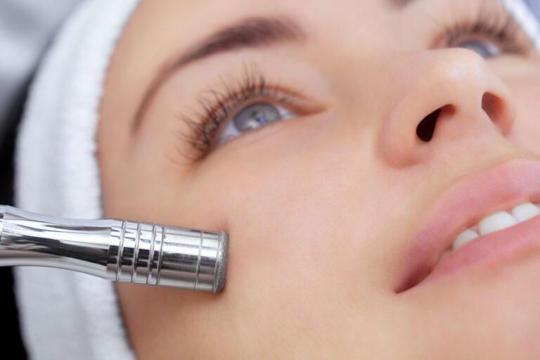 The cosmetologist makes the procedure Microdermabrasion of the facial skin