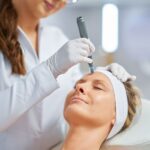 dermatologist applying microneedling on woman's face