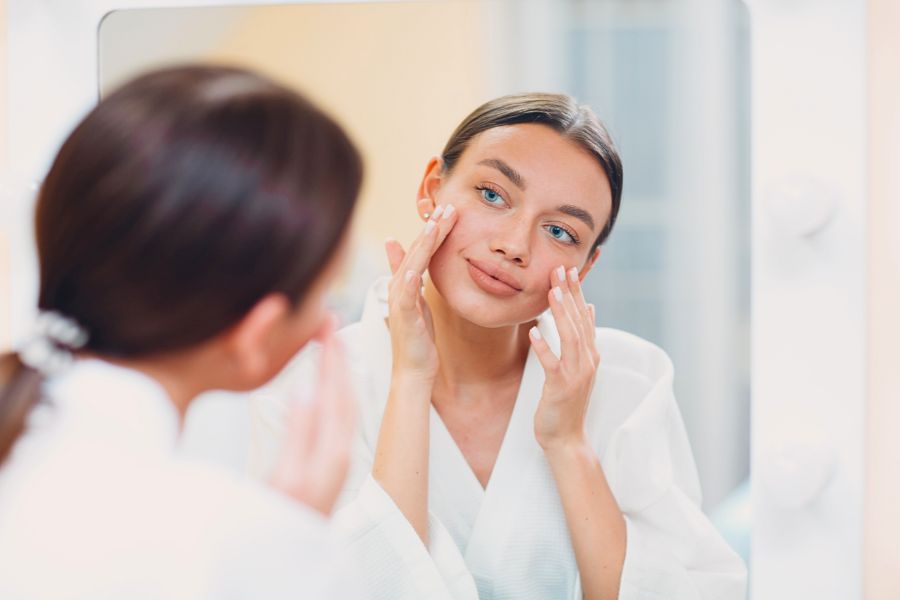 woman applying skincare on face for smile lines