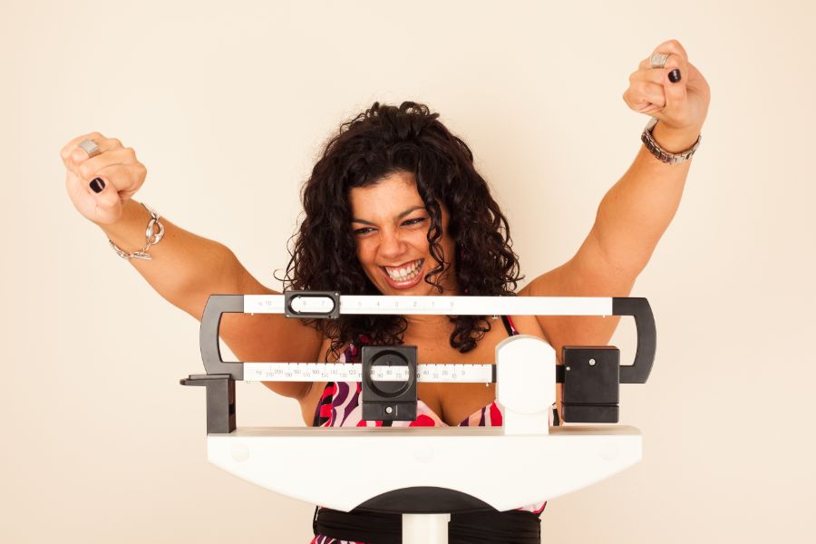 woman happy with weight in weighing scale