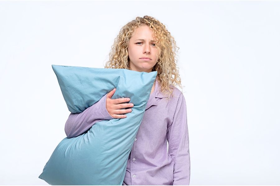 woman holding pillow with poor sleep