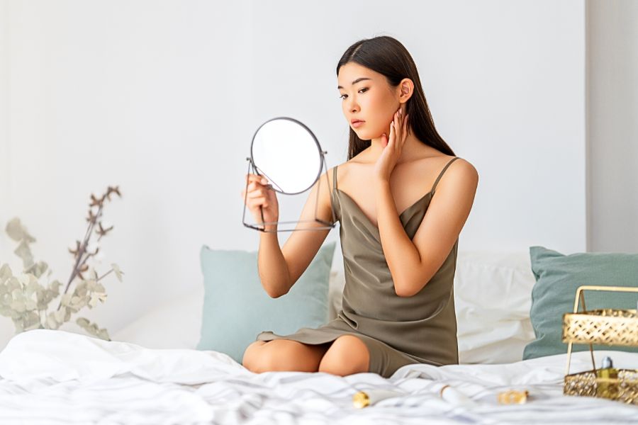 woman looking at skin on the bed