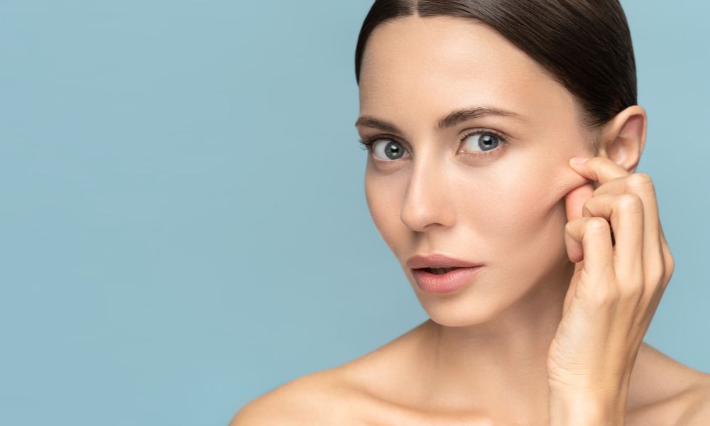 woman touching her nasolabial folds