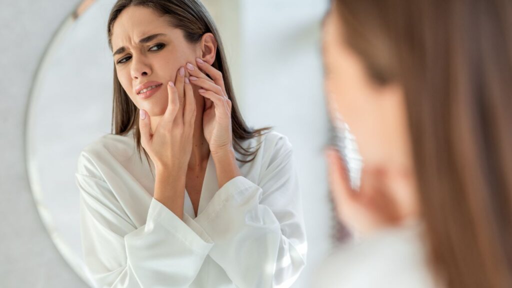 woman with skin concern looking at the mirror