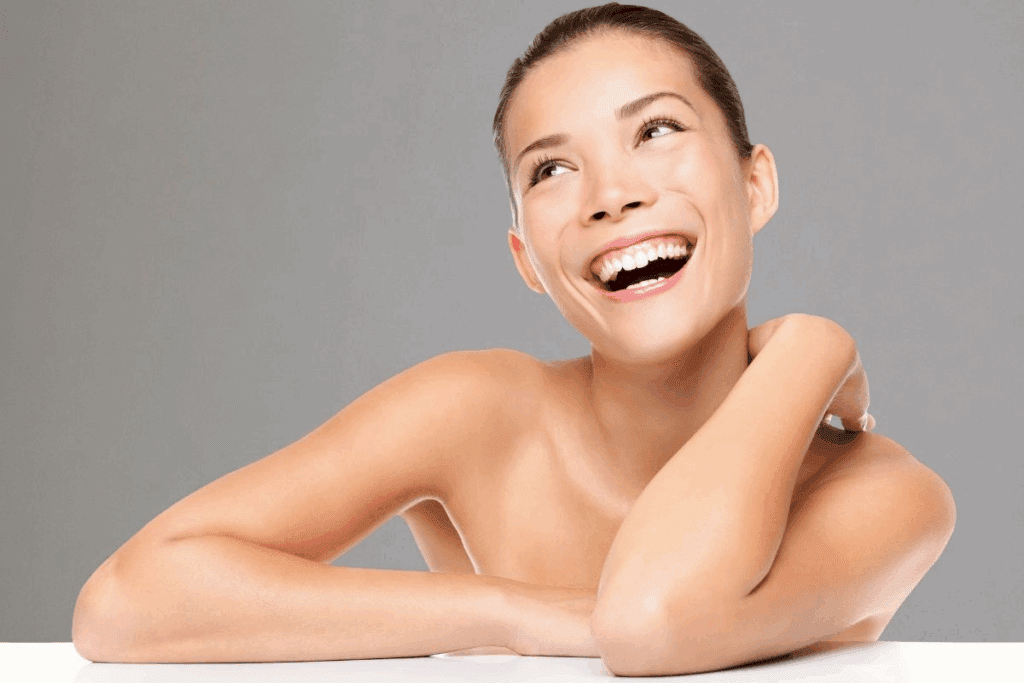 Smiling woman with clear, glowing skin after an acne facial, showing the results of professional treatment for recurring breakouts.