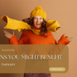 A joyful woman in a bright orange sweater, yellow scarf, and hat gleefully poses against a warm beige background, highlighting IV therapy benefits.