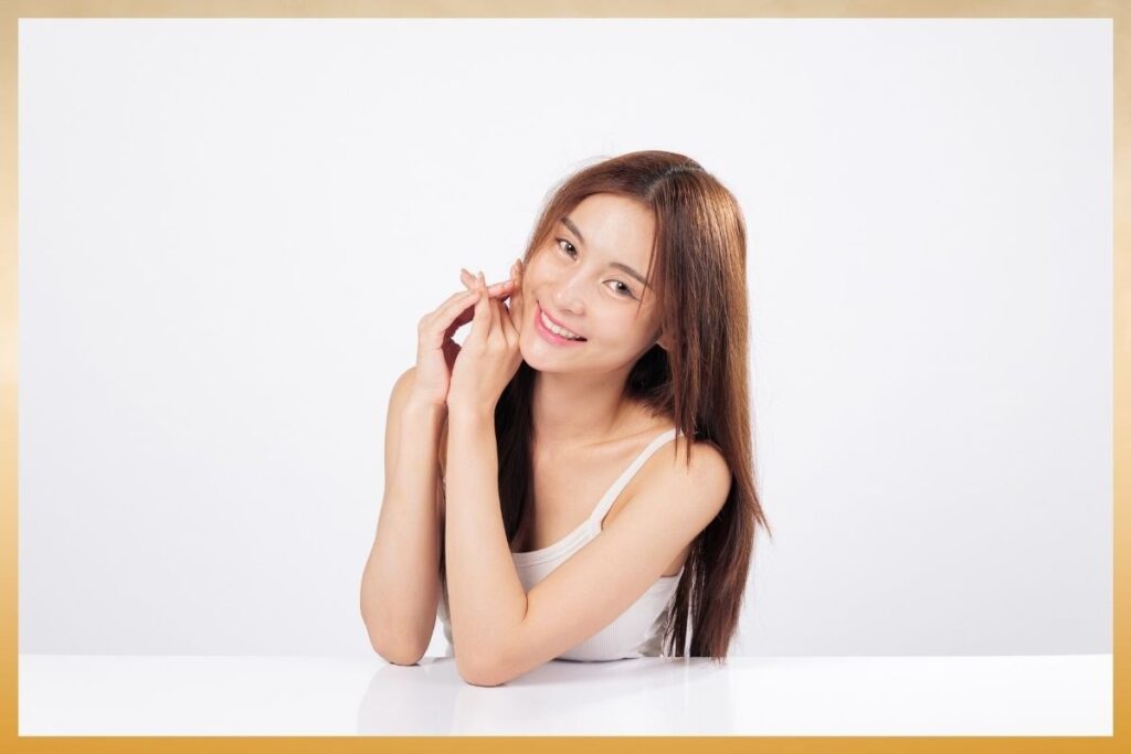 A woman with long brown hair smiles warmly, showing natural radiance achieved through IV therapy for skin at Saint Aesthetix.