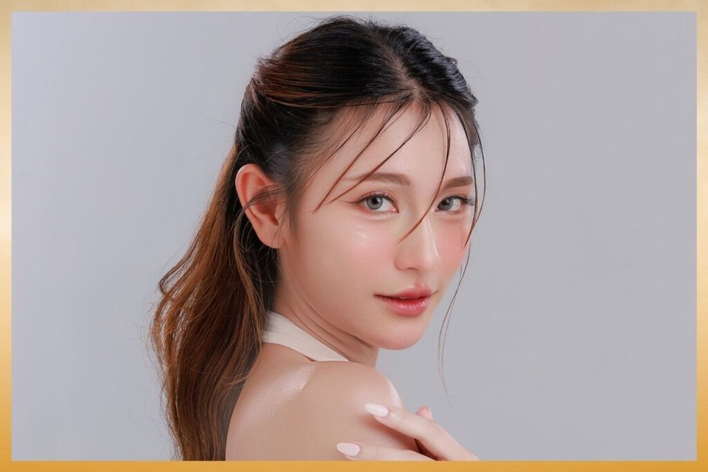 A woman with a ponytail gazes softly at the camera, highlighting healthy, radiant skin from IV therapy for skin treatments.