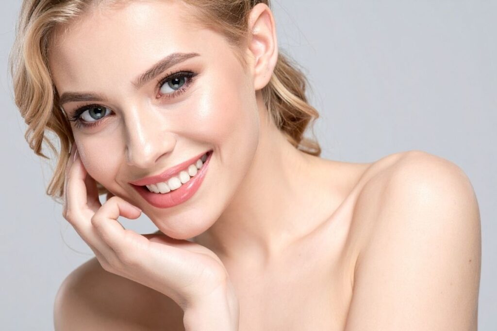 Smiling woman with glowing, hydrated skin reflecting the benefits of addressing common IV therapy misconceptions for wellness.