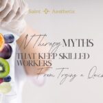 A gloved hand holds an IV bag filled with colorful fruits like kiwi, orange, berries, and grapes, illustrating IV therapy myths that keep skilled workers from trying a quick fix.