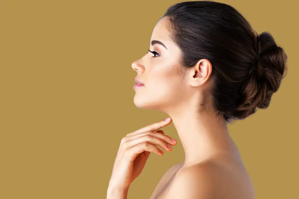 Side profile of a woman with her hair in an elegant bun touching her neck.