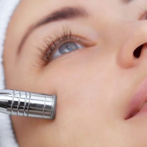The cosmetologist makes the procedure Microdermabrasion of the facial skin