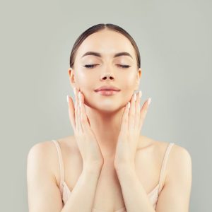 Lady touching glowing face dermatology