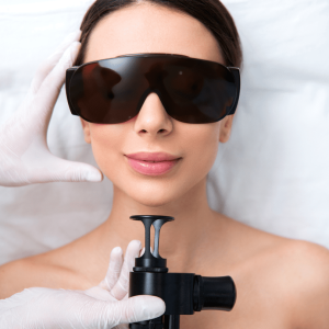 doctor's hand touching the face of a patient and holding an erbium laser