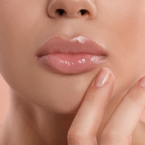 young woman with beautiful full lips on peach background