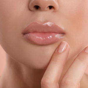 young woman with beautiful full lips on peach background