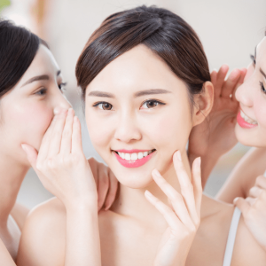 three happy asian women whispering on each other about iv therapy