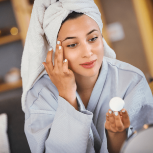 woman applying cream on her face