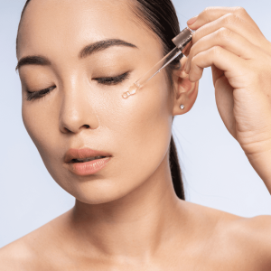 woman applying vitamin c serum to her face